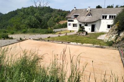 Tables dressées pour un repas en extérieur devant une maison en pierre et crépi, avec une borne photo à gauche.