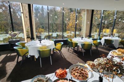 Un public assis dans une salle de conférence, attentif à une présentation sur une scène éclairée.