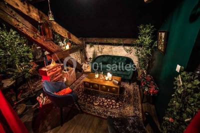 Comptoir de bar sombre avec des bougies allumées, décoré de motifs floraux et éclairé par une lumière tamisée.