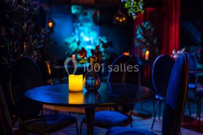 Bar décoré de plantes, bougies et éclairage tamisé, avec un robinet de bière en métal sur le comptoir.