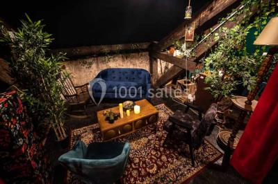 Bar décoré de plantes, bougies et éclairage tamisé, avec un robinet de bière en métal sur le comptoir.