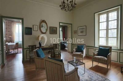 Façade d'un bâtiment illuminée par des motifs colorés, avec guirlandes lumineuses et leur reflet dans un plan d'eau.