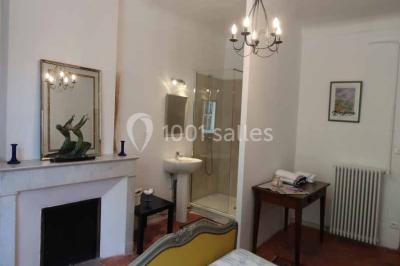 Façade d'un bâtiment illuminée par des motifs colorés, avec guirlandes lumineuses et leur reflet dans un plan d'eau.