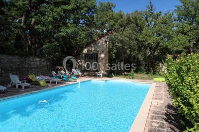 Façade d'un bâtiment illuminée par des motifs colorés, avec guirlandes lumineuses et leur reflet dans un plan d'eau.