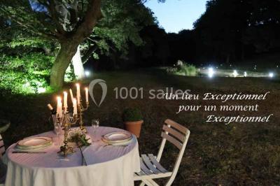 Façade d'un bâtiment illuminée par des motifs colorés, avec guirlandes lumineuses et leur reflet dans un plan d'eau.