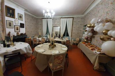 Façade d'un bâtiment illuminée par des motifs colorés, avec guirlandes lumineuses et leur reflet dans un plan d'eau.