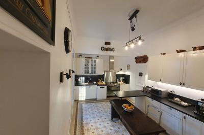 Façade d'un bâtiment illuminée par des motifs colorés, avec guirlandes lumineuses et leur reflet dans un plan d'eau.