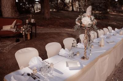 Façade d'un bâtiment illuminée par des motifs colorés, avec guirlandes lumineuses et leur reflet dans un plan d'eau.