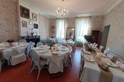 Façade d'un bâtiment illuminée par des motifs colorés, avec guirlandes lumineuses et leur reflet dans un plan d'eau.