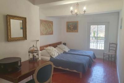 Façade d'un bâtiment illuminée par des motifs colorés, avec guirlandes lumineuses et leur reflet dans un plan d'eau.