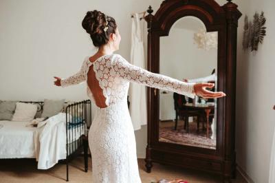 Façade d'un bâtiment illuminée par des motifs colorés, avec guirlandes lumineuses et leur reflet dans un plan d'eau.