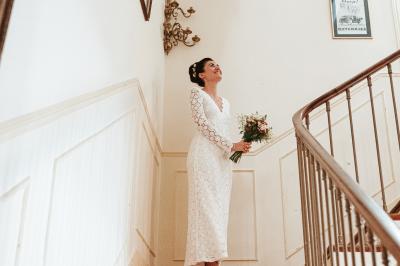 Façade d'un bâtiment illuminée par des motifs colorés, avec guirlandes lumineuses et leur reflet dans un plan d'eau.