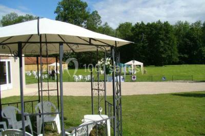 Façade d'un bâtiment avec des portes en bois et des fenêtres à volets, sous un ciel bleu dégagé.