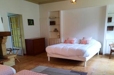 Façade d'un bâtiment avec des portes en bois et des fenêtres à volets, sous un ciel bleu dégagé.