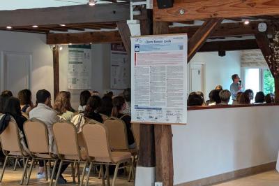 Façade d'un bâtiment avec des portes en bois et des fenêtres à volets, sous un ciel bleu dégagé.