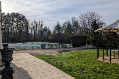 Façade d'un bâtiment avec des portes en bois et des fenêtres à volets, sous un ciel bleu dégagé.