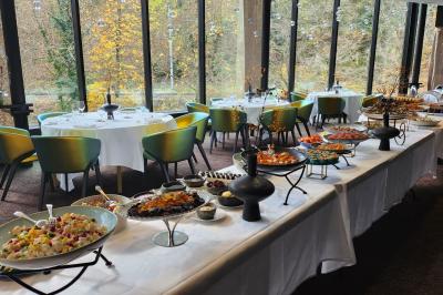 Cascade naturelle entourée de végétation, se déversant dans un bassin calme sous une lumière ensoleillée.