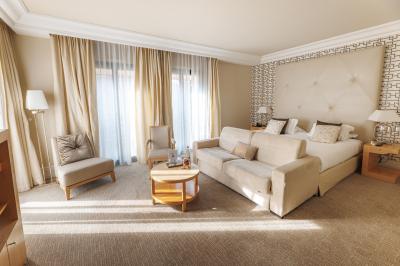 Cascade naturelle entourée de végétation, se déversant dans un bassin calme sous une lumière ensoleillée.