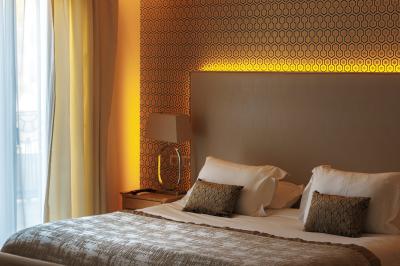 Cascade naturelle entourée de végétation, se déversant dans un bassin calme sous une lumière ensoleillée.