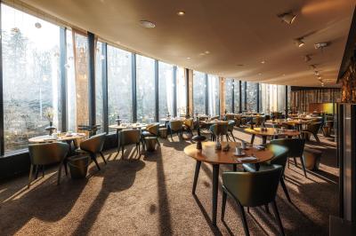 Cascade naturelle entourée de végétation, se déversant dans un bassin calme sous une lumière ensoleillée.