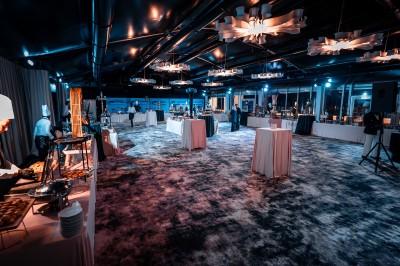 Des personnes jouent à la pétanque sur un terrain en plein air, entouré de verdure.