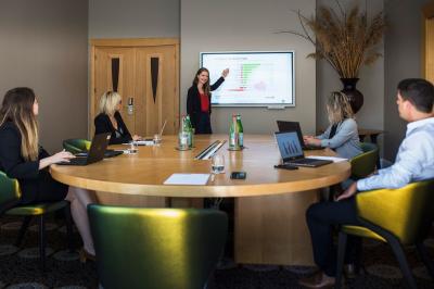 Cascade naturelle entourée de végétation, se déversant dans un bassin calme sous une lumière ensoleillée.