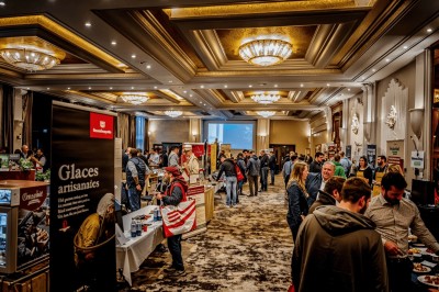 Des personnes jouent à la pétanque sur un terrain en plein air, entouré de verdure.