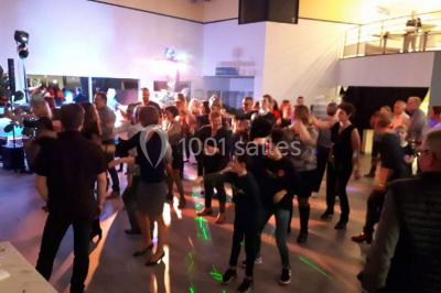 Miniature Location salle Saint-Contest (Calvados) - L'Essentiel #13 Salle comble avec des participants assis et debout lors d'un événement, décorée avec un sapin de Noël et des tableaux muraux.