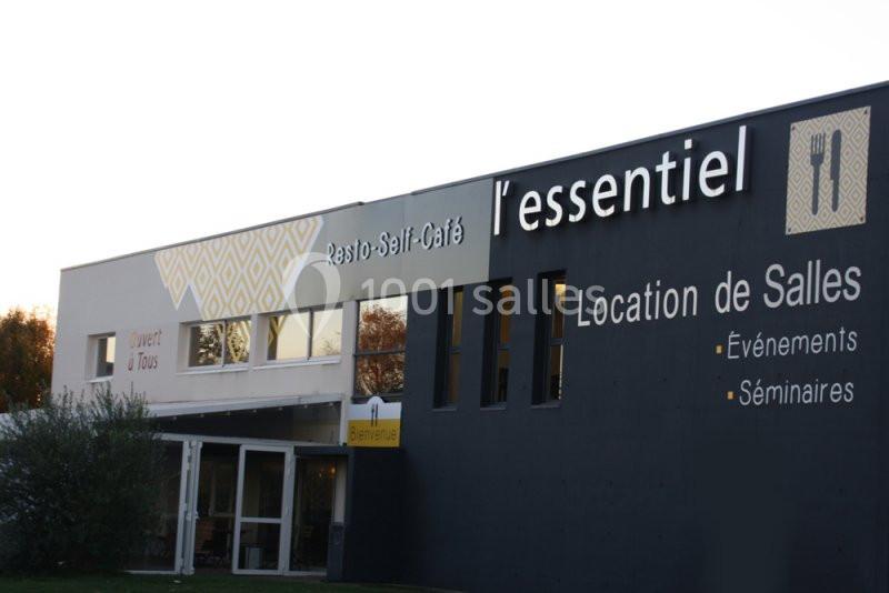 Façade d'un bâtiment avec enseignes indiquant ’l'essentiel’, un restaurant et espace de location de salles.