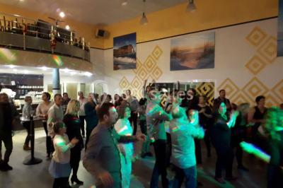 Miniature Location salle Saint-Contest (Calvados) - L'Essentiel #17 Salle comble avec des participants assis et debout lors d'un événement, décorée avec un sapin de Noël et des tableaux muraux.