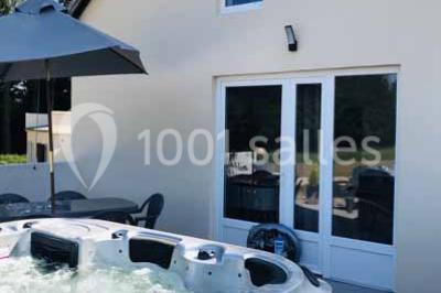 Bancs en bois disposés en extérieur, ornés de sacs en papier, avec une table blanche en arrière-plan près d'un étang.