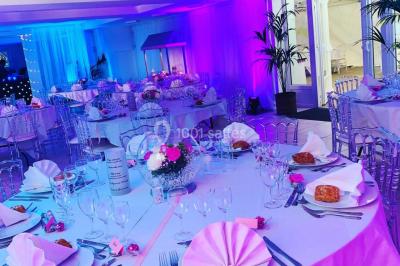 Bancs en bois disposés en extérieur, ornés de sacs en papier, avec une table blanche en arrière-plan près d'un étang.