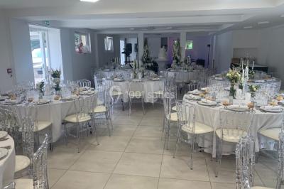 Bancs en bois disposés en extérieur, ornés de sacs en papier, avec une table blanche en arrière-plan près d'un étang.