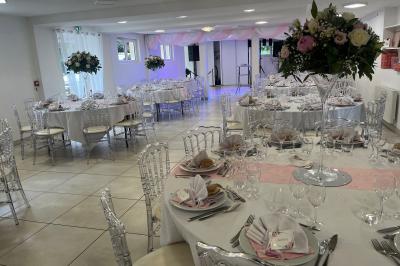 Bancs en bois disposés en extérieur, ornés de sacs en papier, avec une table blanche en arrière-plan près d'un étang.