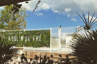 Bancs en bois disposés en extérieur, ornés de sacs en papier, avec une table blanche en arrière-plan près d'un étang.