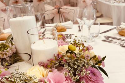 Bancs en bois disposés en extérieur, ornés de sacs en papier, avec une table blanche en arrière-plan près d'un étang.