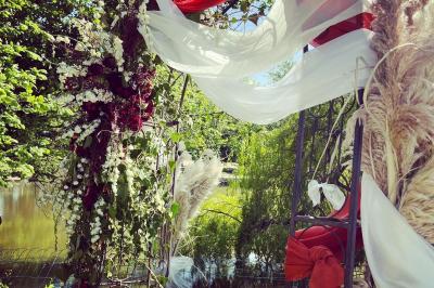Bancs en bois disposés en extérieur, ornés de sacs en papier, avec une table blanche en arrière-plan près d'un étang.