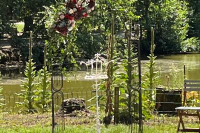 Bancs en bois disposés en extérieur, ornés de sacs en papier, avec une table blanche en arrière-plan près d'un étang.