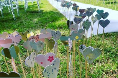 Bancs en bois disposés en extérieur, ornés de sacs en papier, avec une table blanche en arrière-plan près d'un étang.