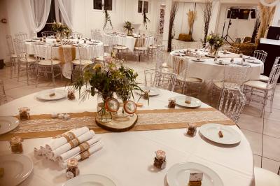 Bancs en bois disposés en extérieur, ornés de sacs en papier, avec une table blanche en arrière-plan près d'un étang.