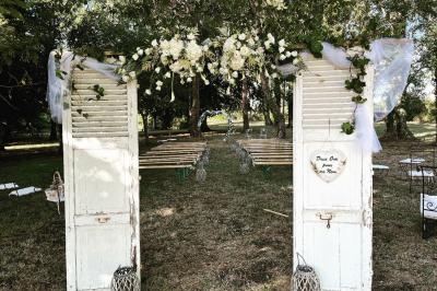 Bancs en bois disposés en extérieur, ornés de sacs en papier, avec une table blanche en arrière-plan près d'un étang.