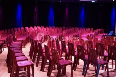Plateaux de petits fours variés disposés sur une table ronde, décorée de feuillage, dans une ambiance tamisée.
