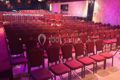 Plateaux de petits fours variés disposés sur une table ronde, décorée de feuillage, dans une ambiance tamisée.