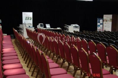 Plateaux de petits fours variés disposés sur une table ronde, décorée de feuillage, dans une ambiance tamisée.