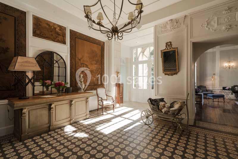 Intérieur lumineux avec mobilier classique, carrelage ancien, panneaux décoratifs et vue sur une pièce adjacente.