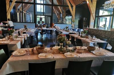 Une femme en robe de mariée sourit face à un homme en costume orange dans un vignoble verdoyant.