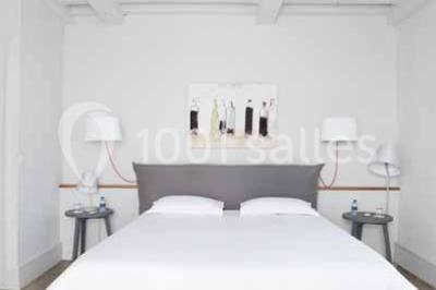 Façade d'une maison en pierre avec toit en tuiles, entourée de végétation dense sous une lumière douce.