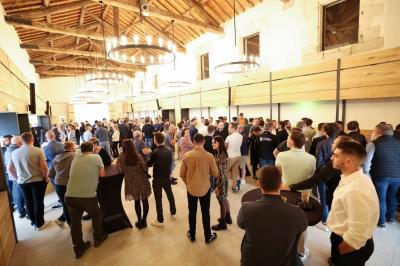 Façade d'une maison en pierre avec toit en tuiles, entourée de végétation dense sous une lumière douce.