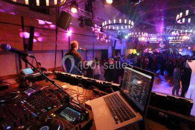 Façade d'une maison en pierre avec toit en tuiles, entourée de végétation dense sous une lumière douce.