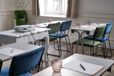 Chambre lumineuse avec lit double, canapé, fauteuils, table ronde et décoration murale dans un intérieur aux tons jaunes.